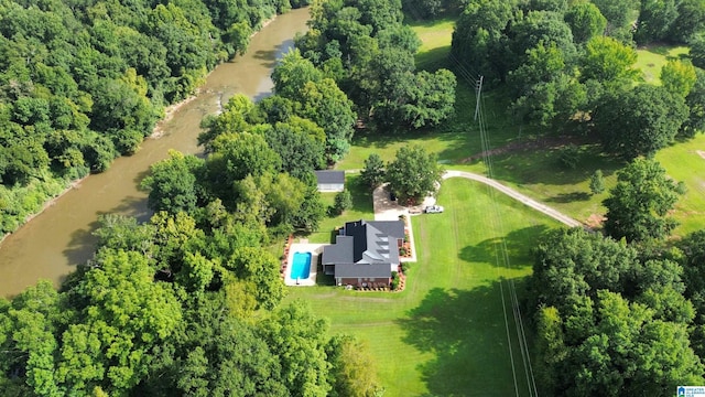 birds eye view of property with a water view and a wooded view