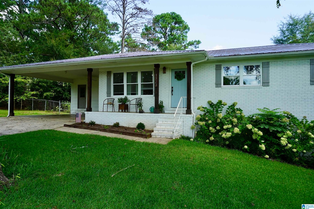 ranch-style house featuring a front yard and a carport