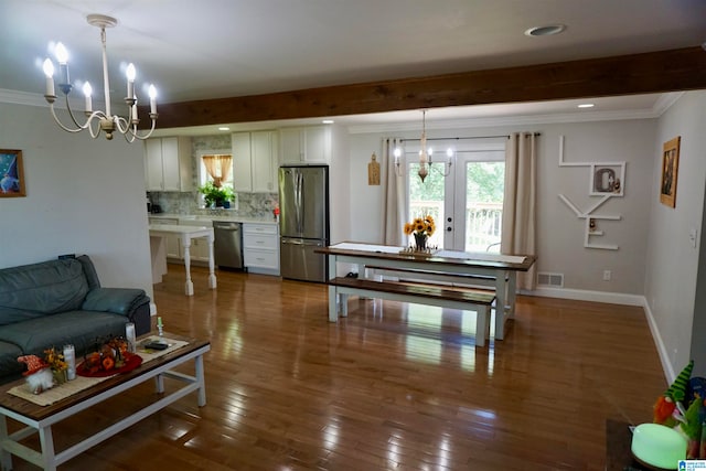 living room with ornamental molding, dark hardwood / wood-style flooring, a chandelier, and beamed ceiling