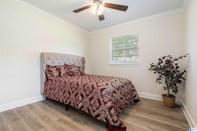 bedroom featuring wood finished floors, crown molding, baseboards, and a ceiling fan