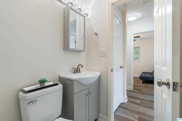 bathroom featuring crown molding, vanity, hardwood / wood-style floors, and toilet