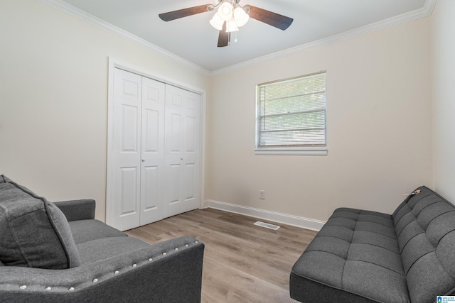 living room featuring ceiling fan, light wood-type flooring, and crown molding