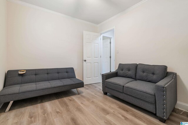 living area featuring wood finished floors, ornamental molding, and baseboards