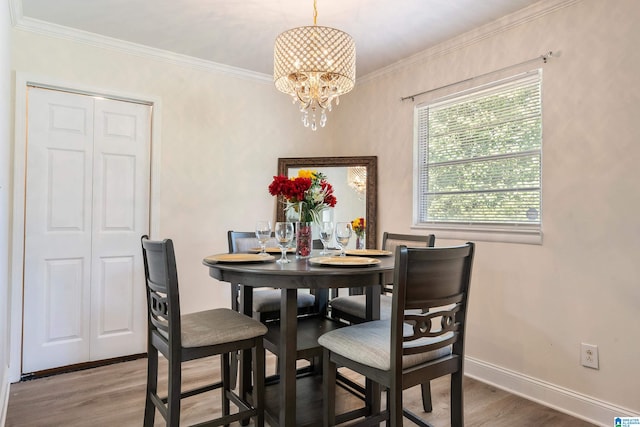 dining room featuring wood-type flooring, ornamental molding, and a chandelier