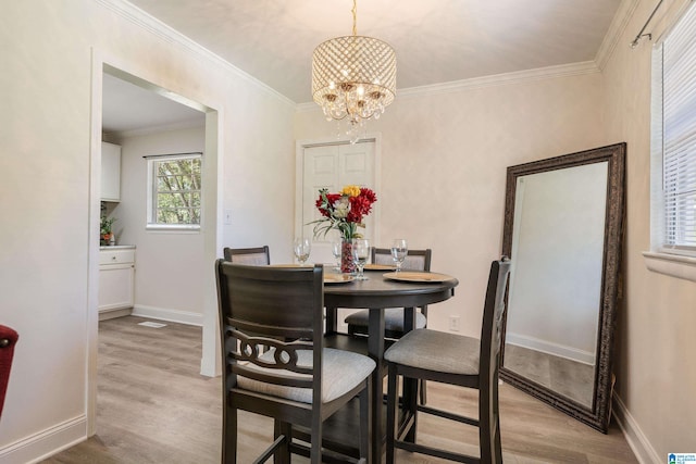 dining space featuring crown molding, an inviting chandelier, and light wood-type flooring