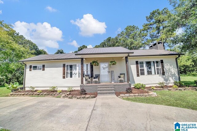 ranch-style house featuring a porch and a front yard