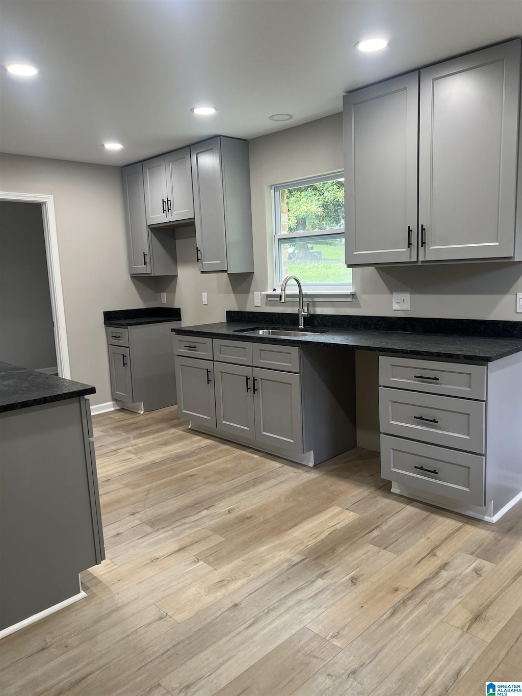 kitchen featuring gray cabinets, light hardwood / wood-style flooring, and sink