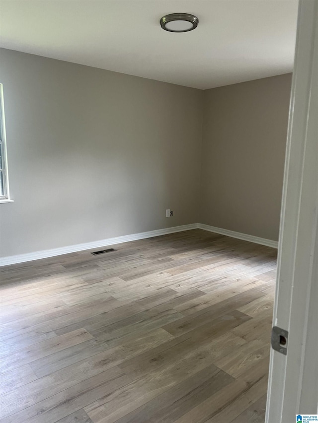 unfurnished room with wood-type flooring