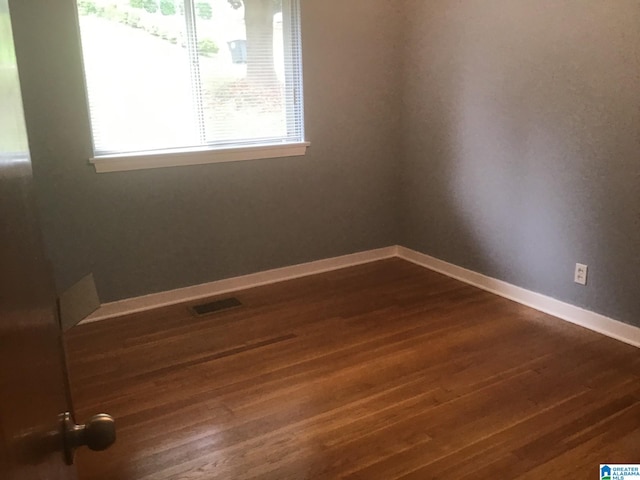 unfurnished room featuring dark hardwood / wood-style flooring