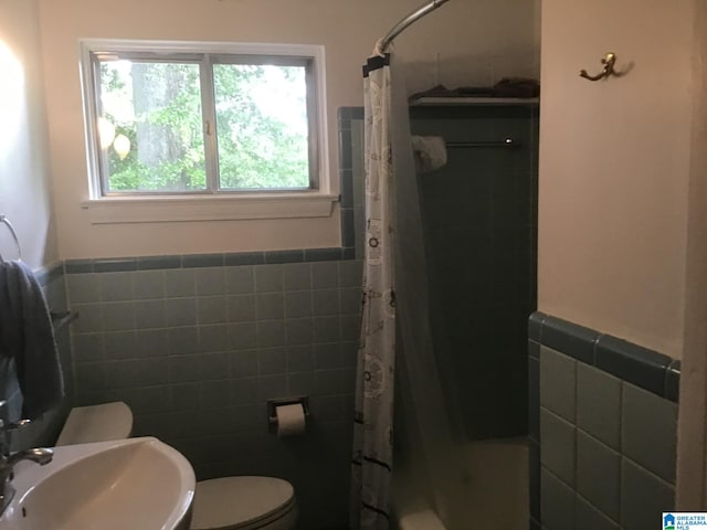 full bathroom with tile walls, sink, toilet, and shower / bath combo with shower curtain