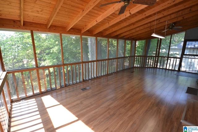 unfurnished sunroom with ceiling fan, wood ceiling, beamed ceiling, and a healthy amount of sunlight