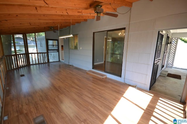 unfurnished sunroom featuring beamed ceiling, wood ceiling, and ceiling fan