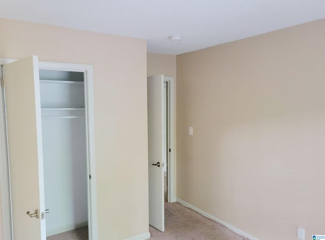 unfurnished bedroom featuring light carpet and a closet