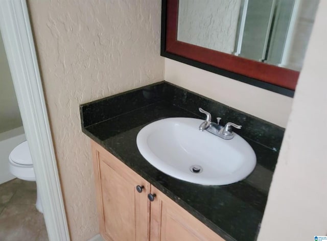 bathroom featuring toilet, tile patterned floors, and vanity