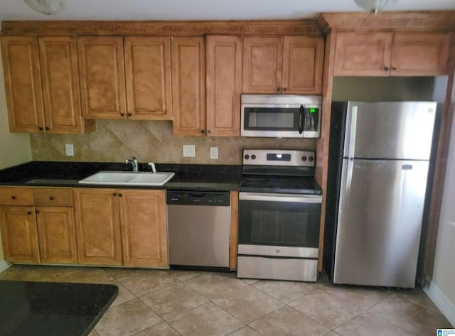 kitchen featuring light tile patterned floors, sink, stainless steel appliances, and decorative backsplash