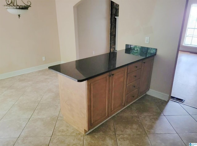 kitchen featuring light tile patterned floors and kitchen peninsula