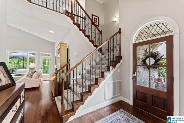 entryway with dark wood-type flooring and a high ceiling