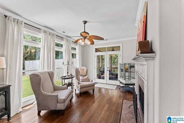 sitting room featuring crown molding, french doors, dark wood-type flooring, and a healthy amount of sunlight