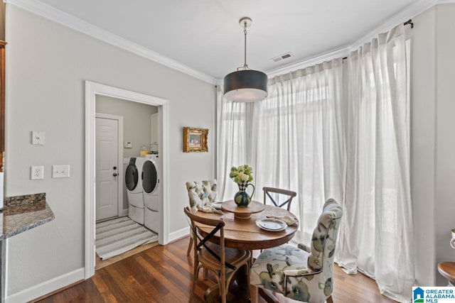 dining area with ornamental molding, dark hardwood / wood-style floors, and separate washer and dryer