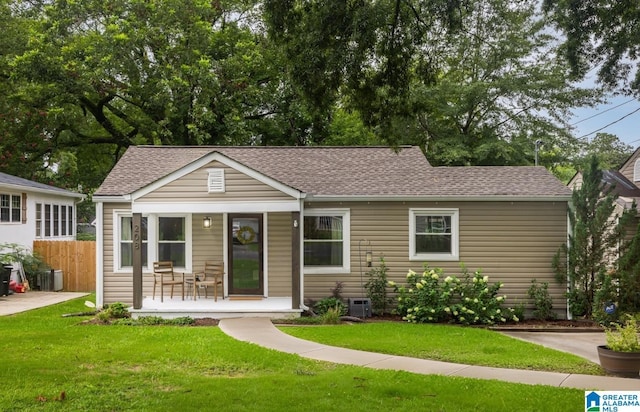 view of front of house featuring a front yard, crawl space, roof with shingles, and fence