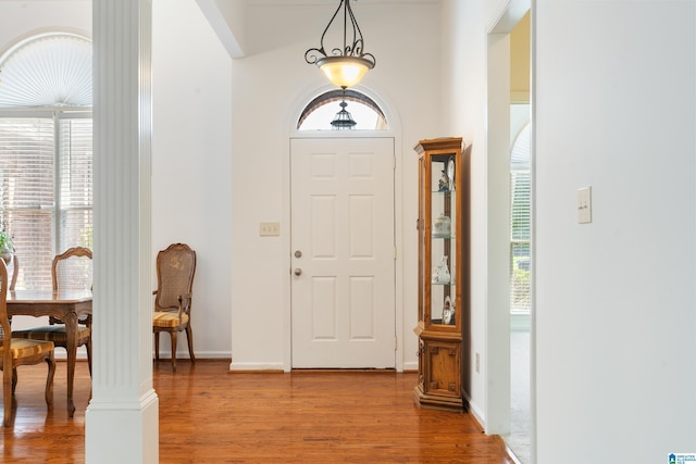 entrance foyer featuring hardwood / wood-style flooring, plenty of natural light, and decorative columns