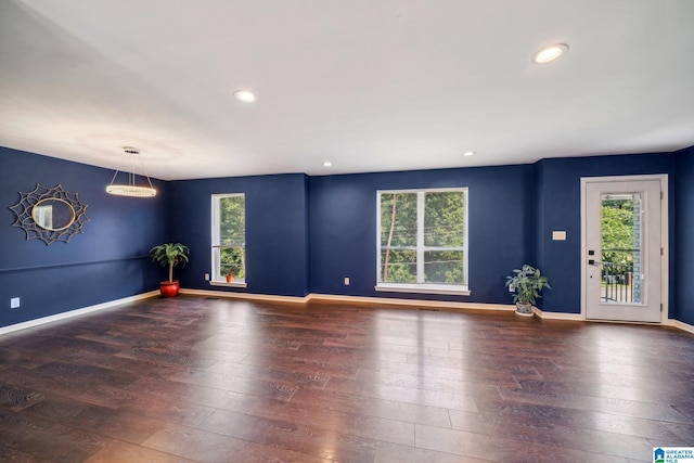 unfurnished room with dark hardwood / wood-style floors and a wealth of natural light