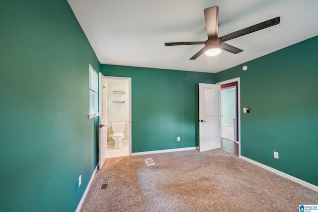 unfurnished bedroom with ceiling fan, ensuite bathroom, and carpet