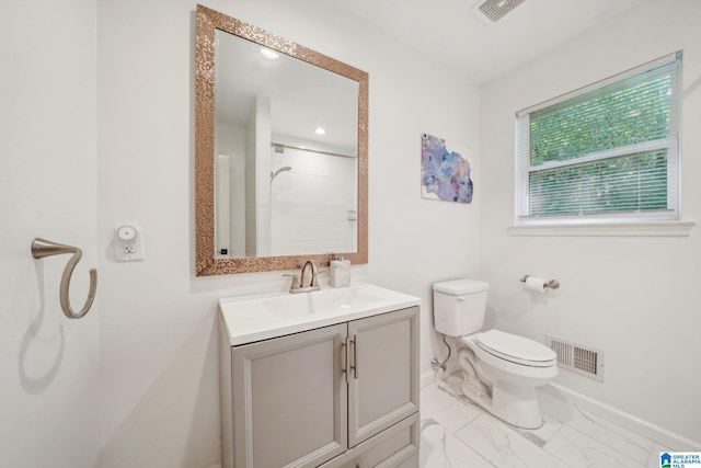 bathroom featuring vanity, toilet, and a shower