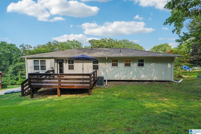 back of property with a wooden deck, a yard, and central AC unit