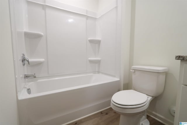 bathroom with shower / bath combination, hardwood / wood-style flooring, and toilet