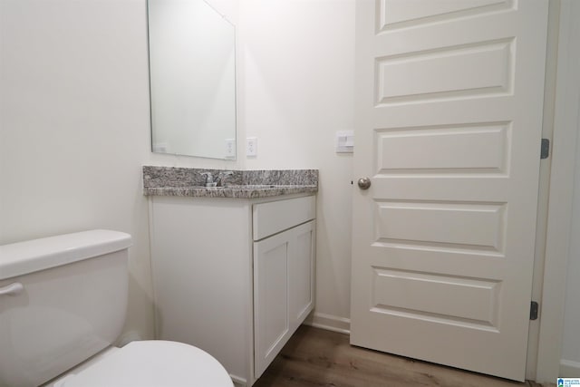 bathroom featuring toilet, vanity, and hardwood / wood-style flooring