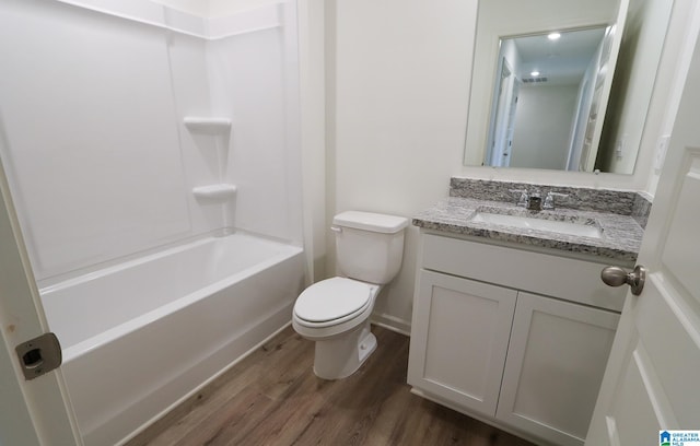 full bathroom with washtub / shower combination, hardwood / wood-style floors, vanity, and toilet