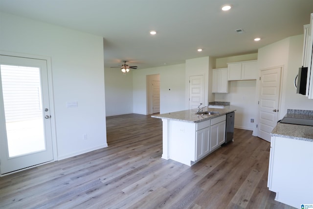 kitchen with a center island with sink, white cabinets, appliances with stainless steel finishes, and light hardwood / wood-style flooring