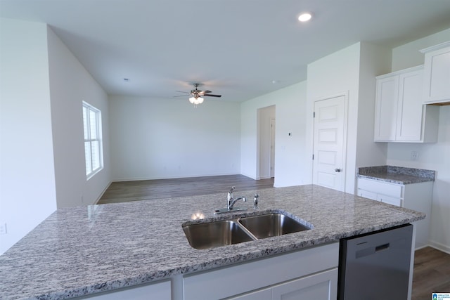 kitchen featuring dishwasher, light stone counters, white cabinetry, and sink