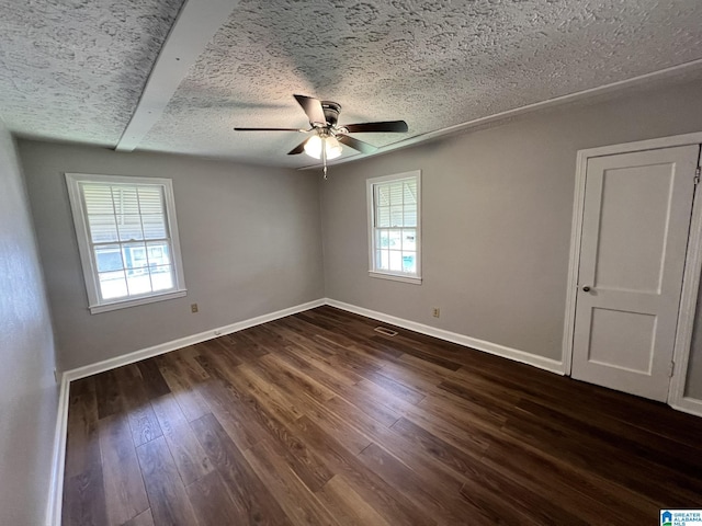 unfurnished room featuring dark hardwood / wood-style flooring, ceiling fan, and a textured ceiling