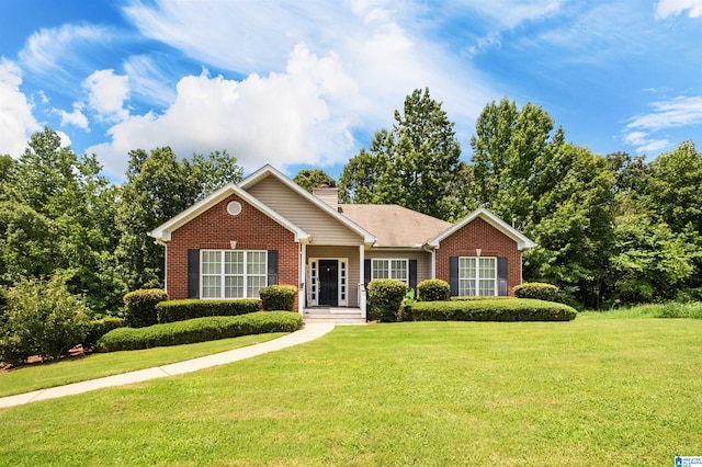 ranch-style house featuring a front yard, brick siding, and a chimney