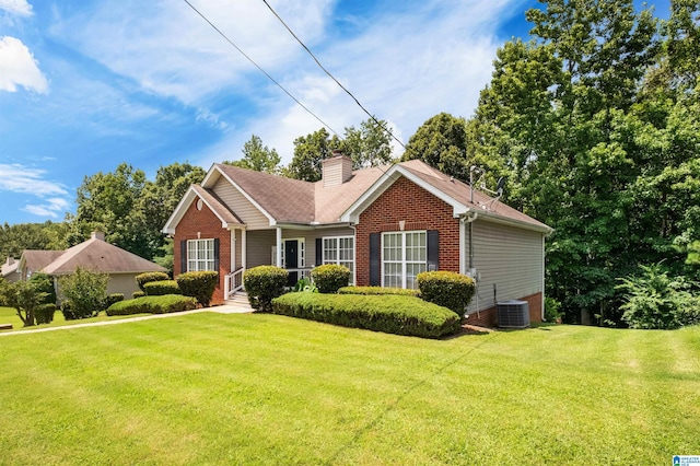 view of front of house featuring a front yard, a chimney, and brick siding