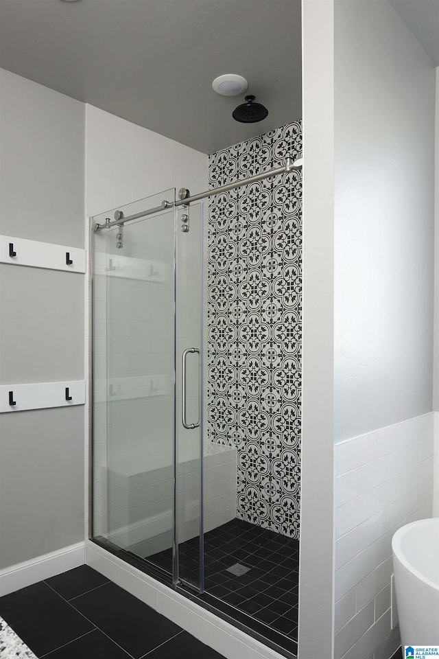 bathroom featuring a shower with shower door, tile patterned flooring, and tile walls