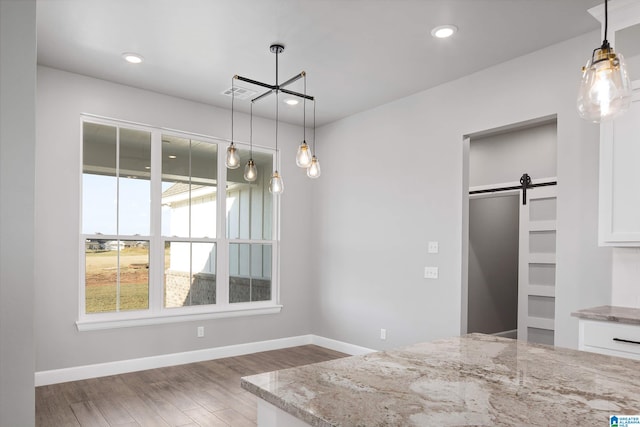 empty room with hardwood / wood-style floors and a barn door