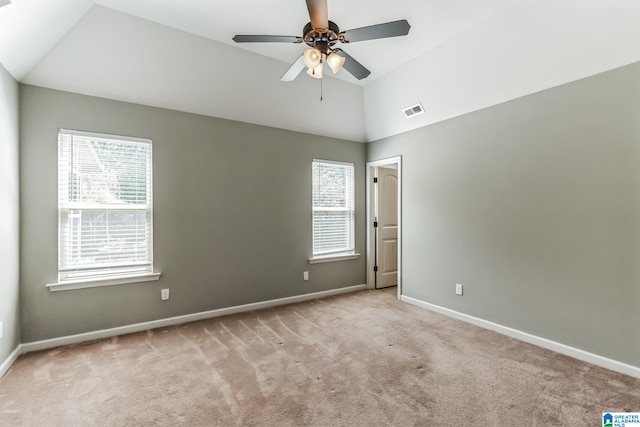 carpeted empty room featuring lofted ceiling, a wealth of natural light, and ceiling fan