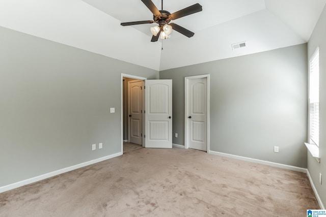 unfurnished bedroom featuring light carpet, vaulted ceiling, and ceiling fan