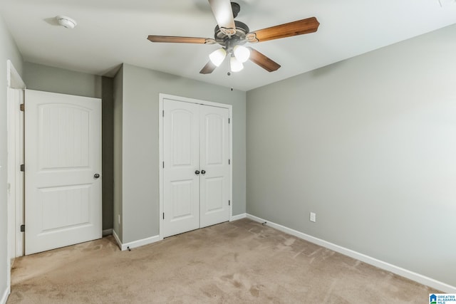 unfurnished bedroom featuring light carpet, a closet, and ceiling fan