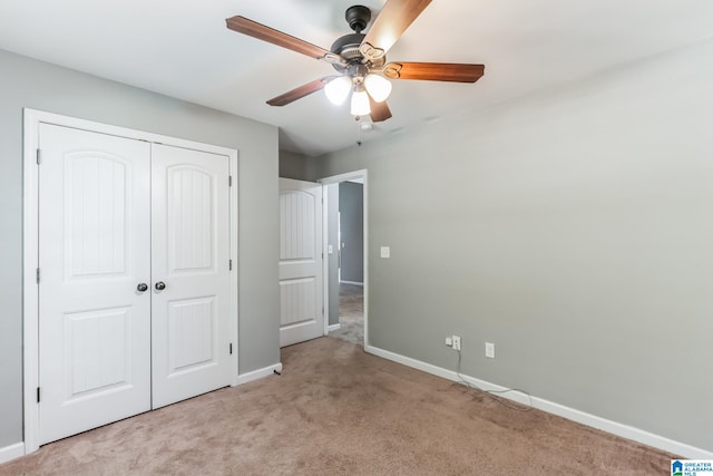 unfurnished bedroom featuring a closet, light colored carpet, and ceiling fan