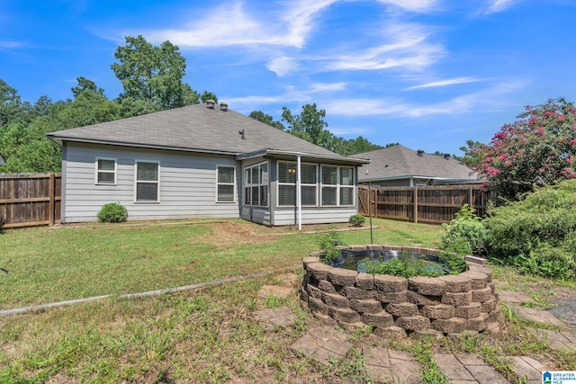 back of property with a yard and a sunroom