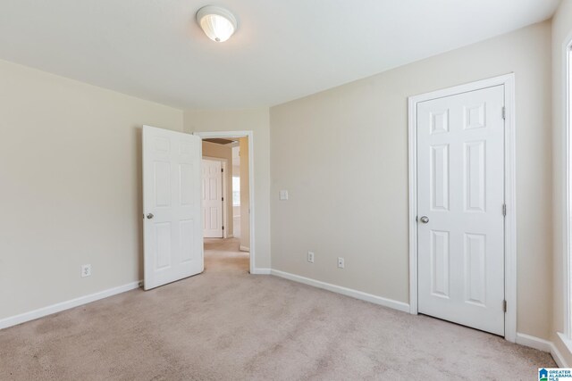 unfurnished bedroom featuring light carpet