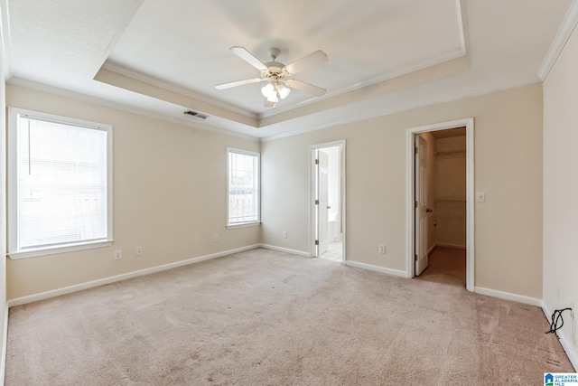 unfurnished bedroom featuring a spacious closet, ensuite bathroom, multiple windows, and light carpet