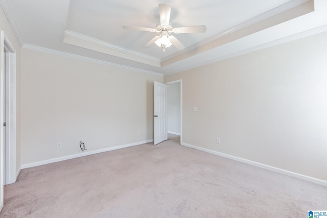 carpeted spare room featuring ceiling fan, a raised ceiling, and ornamental molding