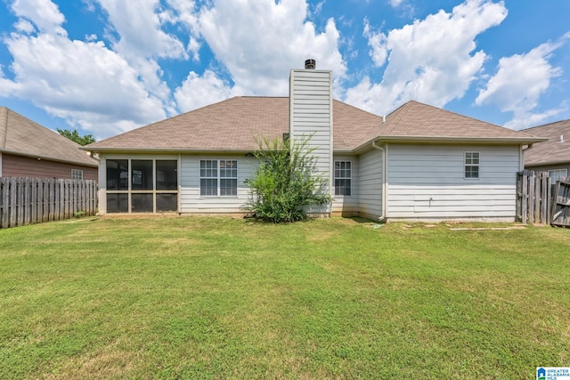 rear view of property with a sunroom and a yard