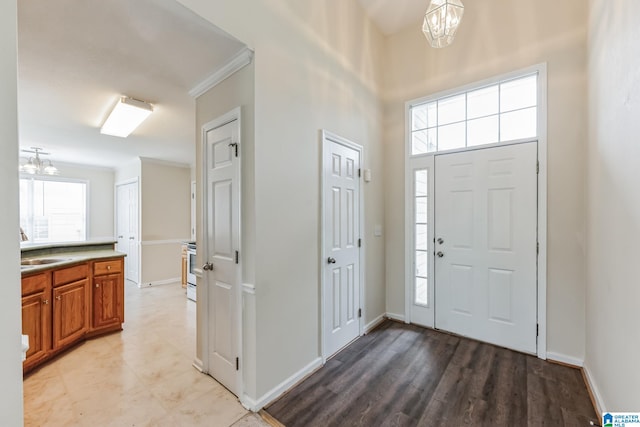 foyer entrance featuring light tile patterned floors, a healthy amount of sunlight, and a chandelier