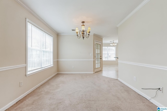 spare room featuring ornamental molding, an inviting chandelier, and carpet